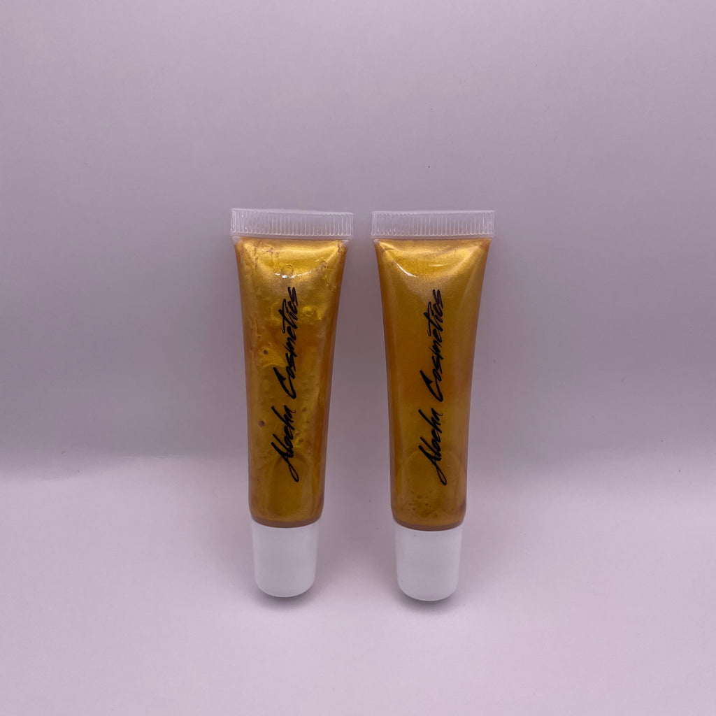 Golden sunset lip gloss shimmering in the warm evening light, giving a luxurious, golden sheen to the lips 